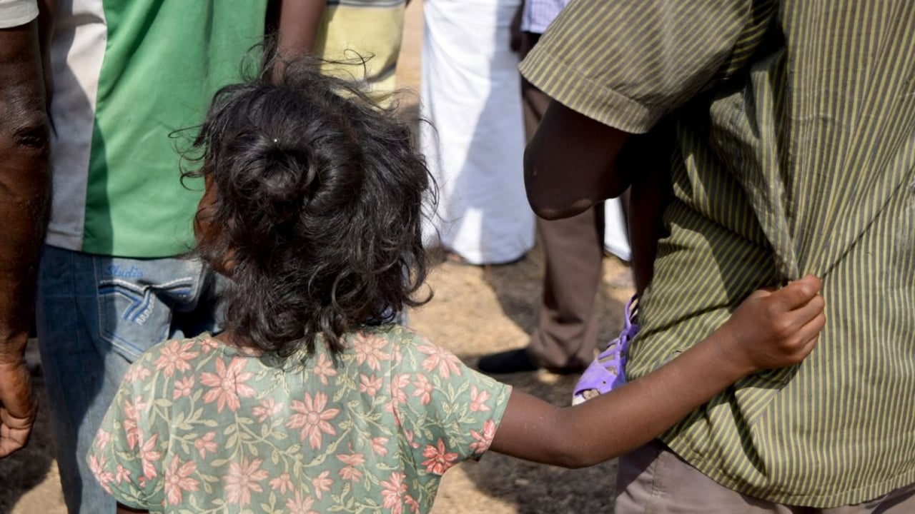 A child holding on to her father during enquiry 180822 181753